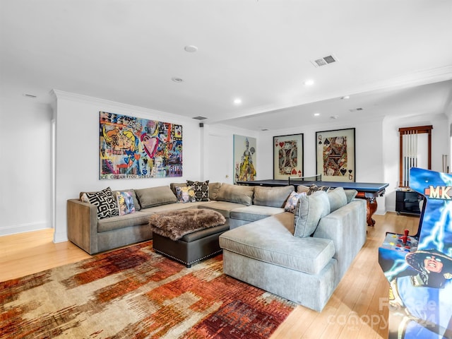 living room with light hardwood / wood-style flooring and crown molding