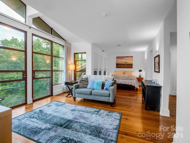 bedroom with vaulted ceiling and hardwood / wood-style flooring