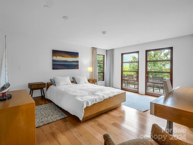 bedroom with light wood-type flooring and access to outside