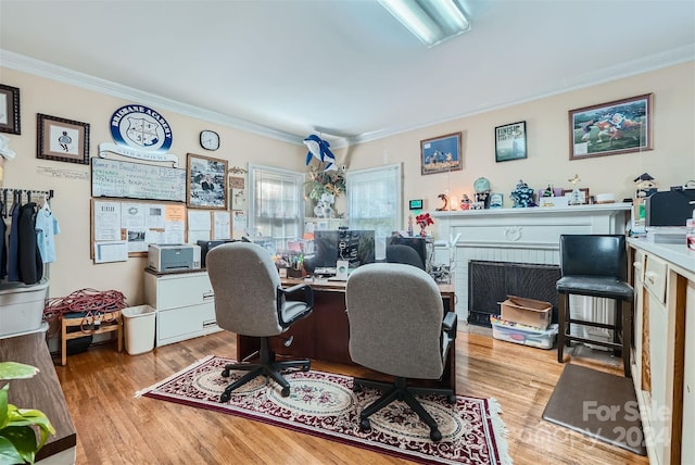 office featuring a brick fireplace, crown molding, and light hardwood / wood-style flooring