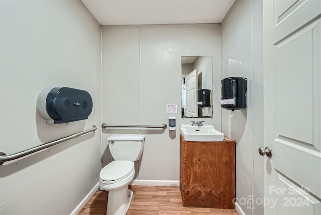 bathroom featuring toilet, vanity, and hardwood / wood-style flooring