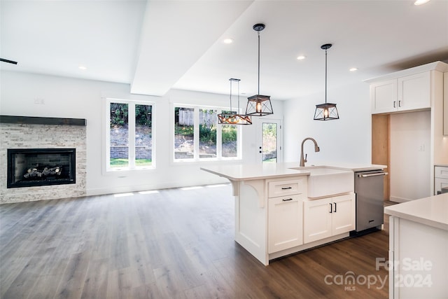 kitchen featuring sink, white cabinets, dishwasher, and an island with sink