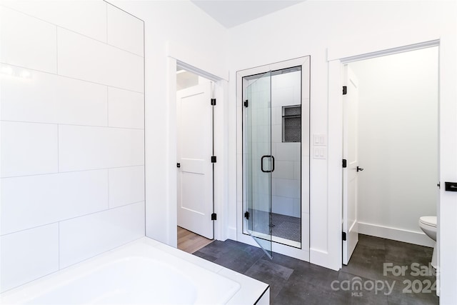 full bath featuring a stall shower, baseboards, toilet, and a bath