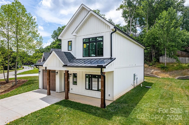 modern inspired farmhouse featuring a garage, a porch, and a front yard