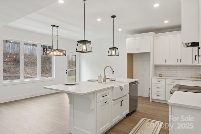 kitchen featuring a sink, white cabinetry, appliances with stainless steel finishes, light countertops, and decorative backsplash