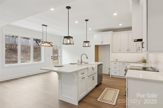 kitchen featuring dishwasher, light countertops, backsplash, and white cabinetry