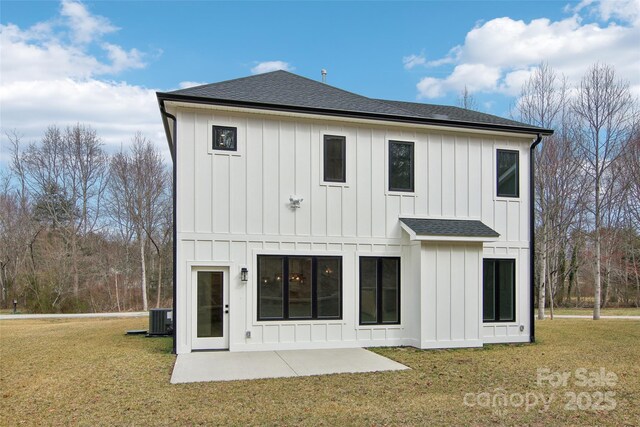 back of house featuring a lawn, board and batten siding, central AC, and roof with shingles