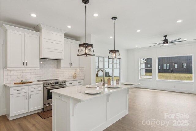 201 Plato Pl, Etowah, NC 28729 - kitchen featuring tasteful backsplash, stainless steel electric range, light wood-style floors, white cabinets, and a sink