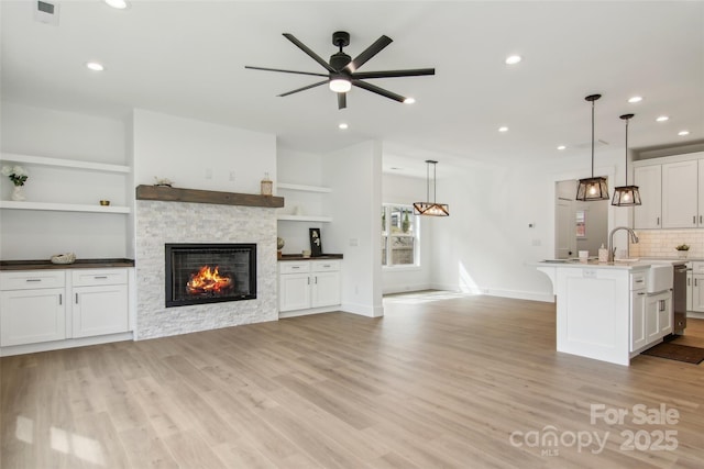 201 Plato Pl, Etowah, NC 28729 - kitchen with light wood finished floors, open floor plan, recessed lighting, a fireplace, and white cabinets