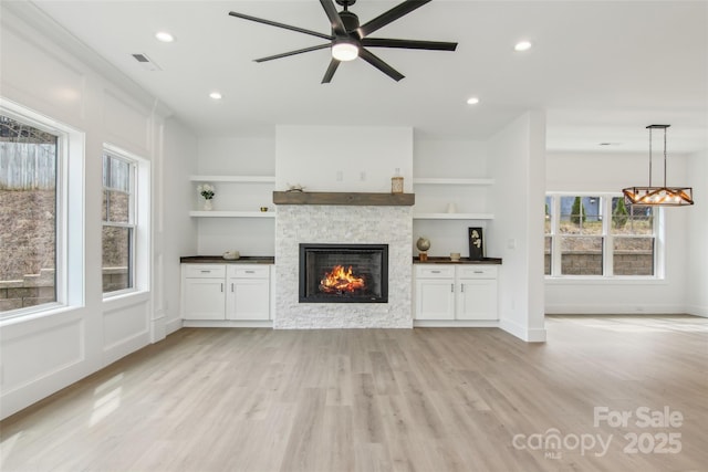 201 Plato Pl, Etowah, NC 28729 - unfurnished living room with light wood finished floors, a fireplace, and a wealth of natural light