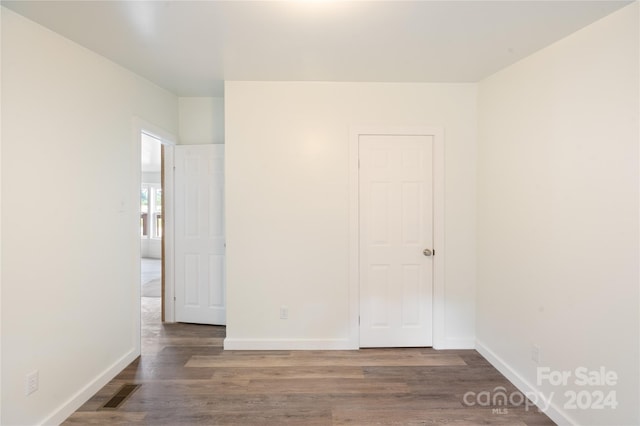 unfurnished bedroom with dark wood-type flooring