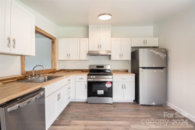 kitchen with sink, white cabinets, appliances with stainless steel finishes, and light hardwood / wood-style flooring