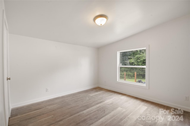 unfurnished room with vaulted ceiling