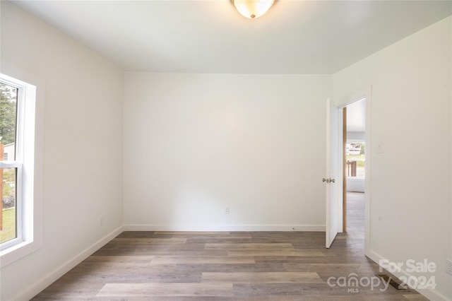 unfurnished room with hardwood / wood-style flooring and plenty of natural light