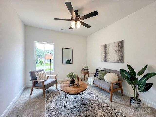 living area featuring light carpet and ceiling fan