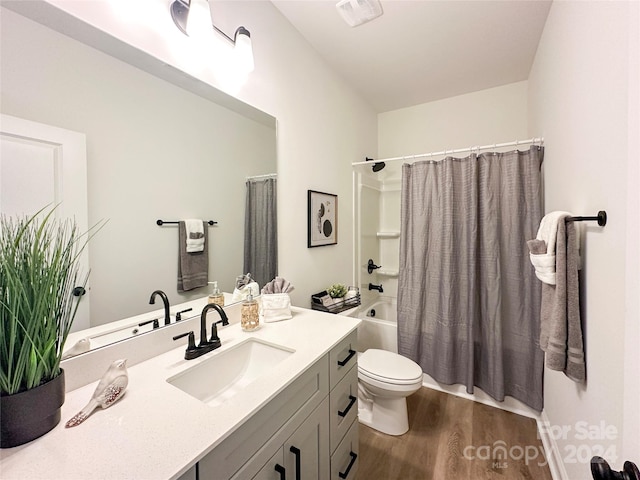 full bathroom with shower / tub combo with curtain, wood-type flooring, toilet, and vanity