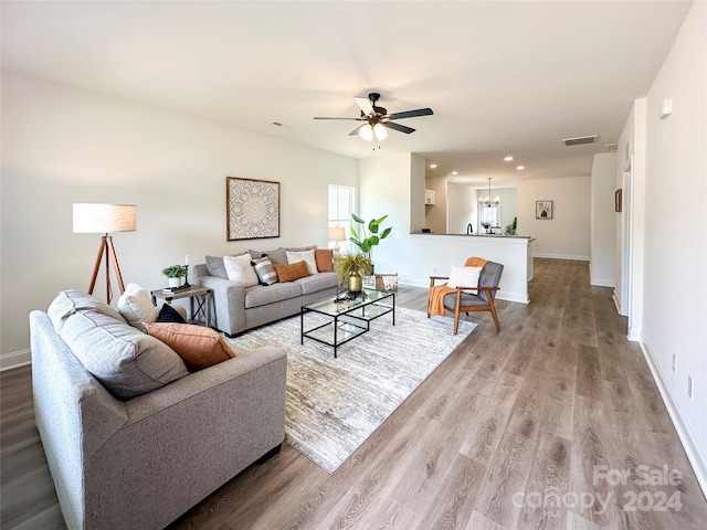 living room with ceiling fan and light hardwood / wood-style flooring