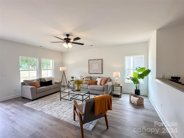 living room featuring ceiling fan, plenty of natural light, and dark hardwood / wood-style floors