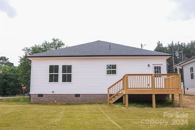 back of house featuring a wooden deck and a lawn