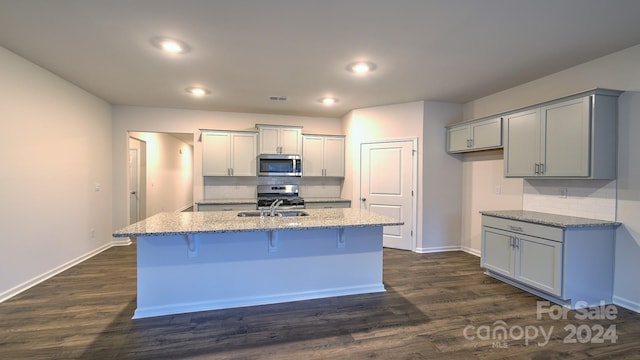 kitchen featuring gray cabinets, light stone countertops, dark wood-type flooring, and appliances with stainless steel finishes