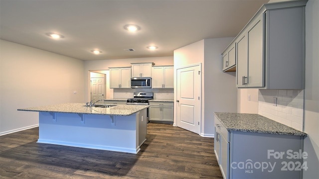 kitchen with stainless steel appliances, gray cabinets, and dark hardwood / wood-style floors