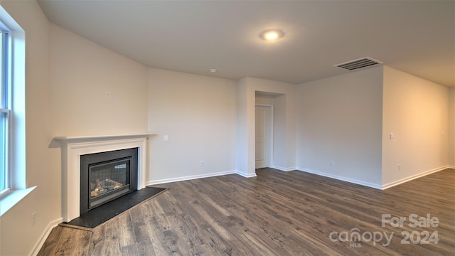 unfurnished living room featuring dark wood-type flooring