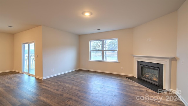 unfurnished living room with dark hardwood / wood-style floors and plenty of natural light