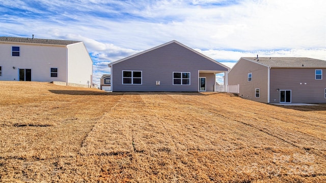 rear view of house featuring a lawn