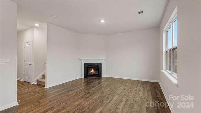 unfurnished living room with dark hardwood / wood-style flooring