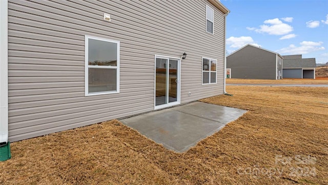 back of house with a patio and a lawn