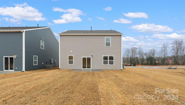 rear view of property featuring a yard and cooling unit