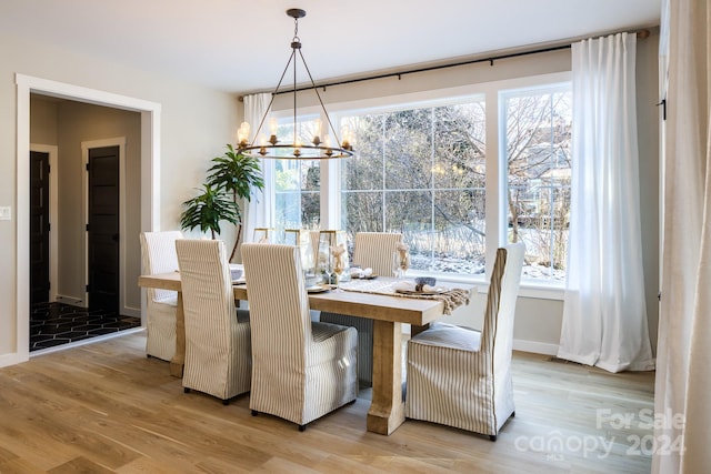 dining area with wood-type flooring and an inviting chandelier