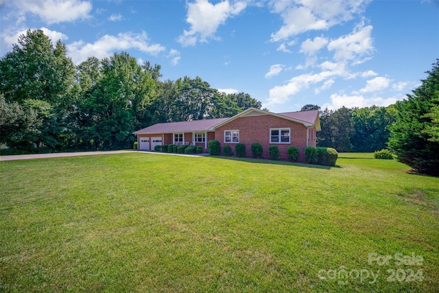 ranch-style house featuring a garage and a front lawn