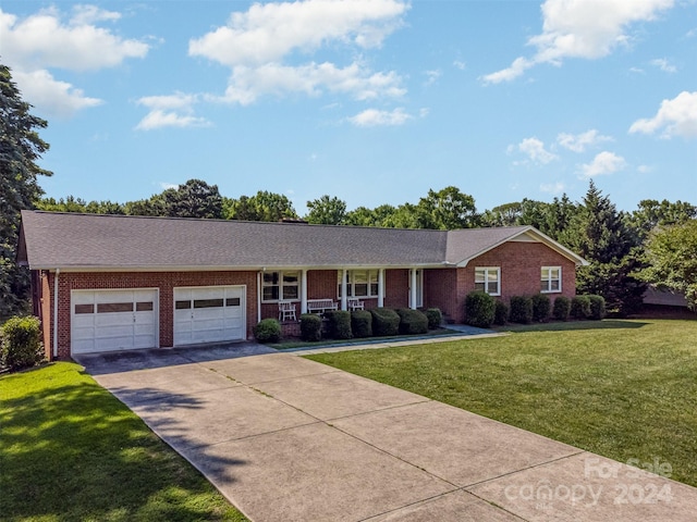 single story home featuring a porch, a garage, and a front lawn