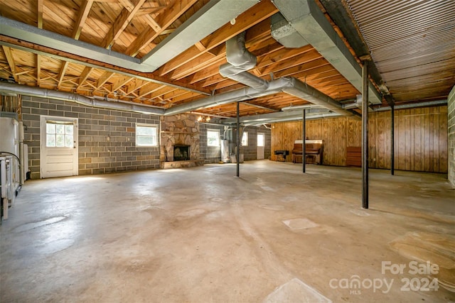 basement featuring a fireplace, white refrigerator, and a wealth of natural light