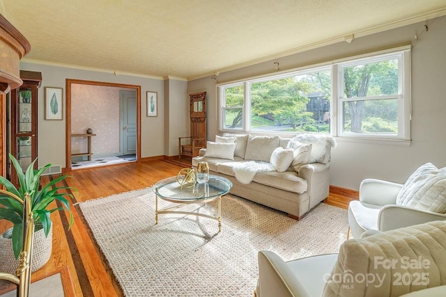 living room with a healthy amount of sunlight, wood-type flooring, and crown molding