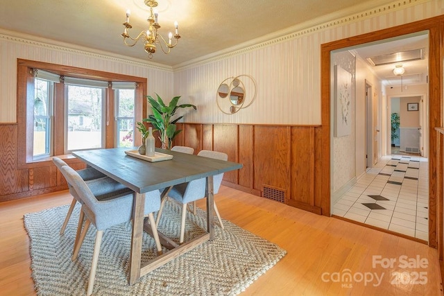 dining room with a chandelier, light hardwood / wood-style floors, and ornamental molding