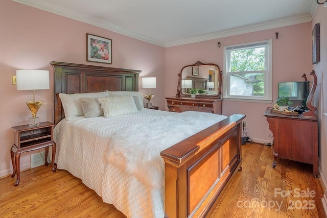 bedroom with light wood-type flooring and crown molding