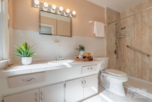 bathroom featuring toilet, vanity, and tiled shower