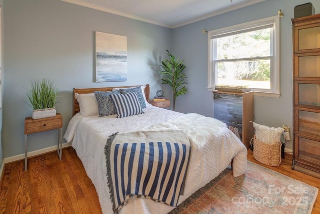 bedroom featuring crown molding and wood-type flooring