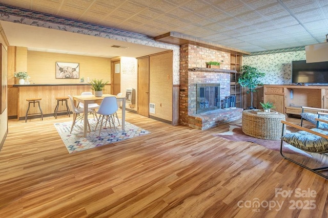 living room with a fireplace and light wood-type flooring