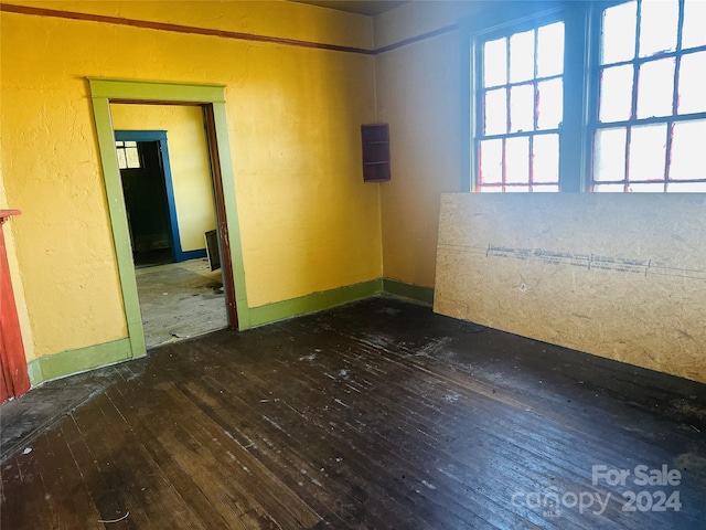 unfurnished room with dark wood-type flooring