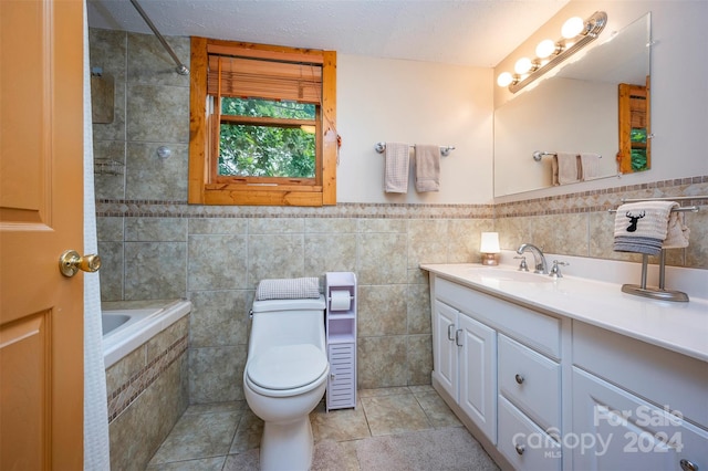 bathroom with a textured ceiling, tile patterned flooring, vanity, tile walls, and toilet