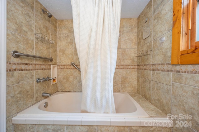 bathroom featuring a textured ceiling and shower / bathtub combination with curtain