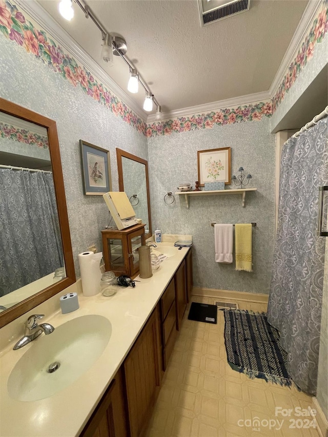 bathroom with vanity, ornamental molding, and a textured ceiling