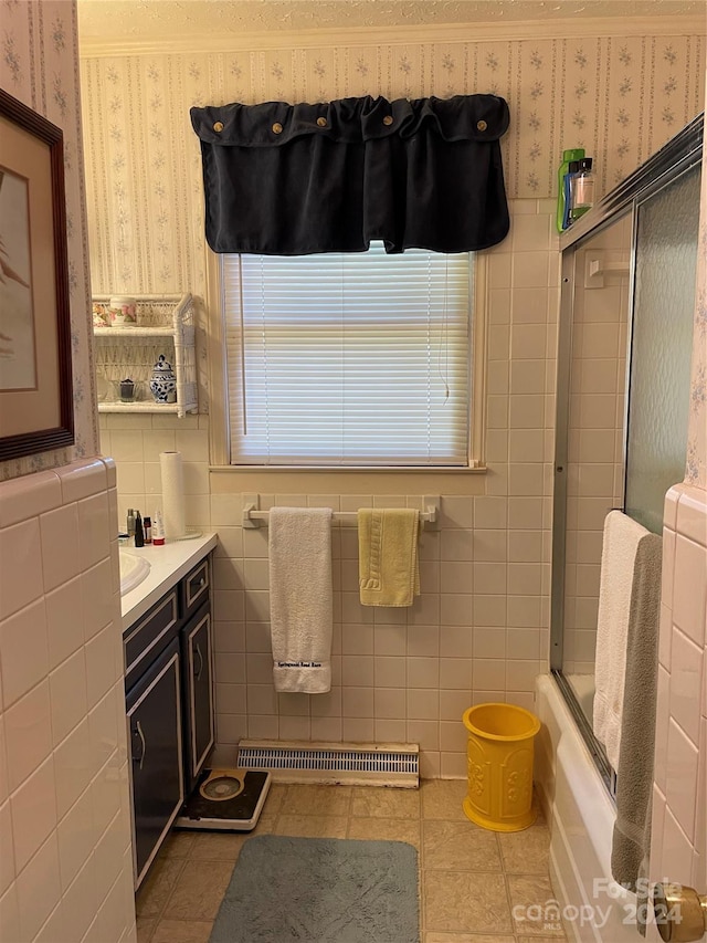 bathroom featuring bath / shower combo with glass door, tile patterned floors, vanity, and tile walls