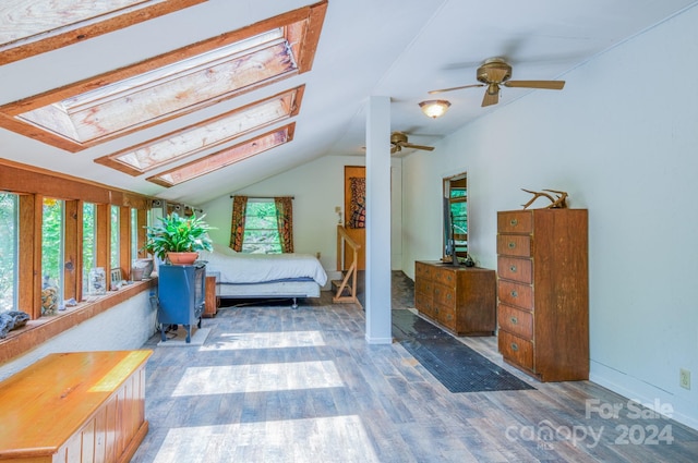 bedroom featuring ceiling fan, hardwood / wood-style flooring, and lofted ceiling with skylight