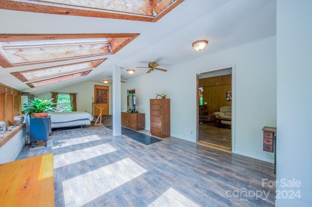 unfurnished bedroom featuring dark wood-type flooring and lofted ceiling with skylight