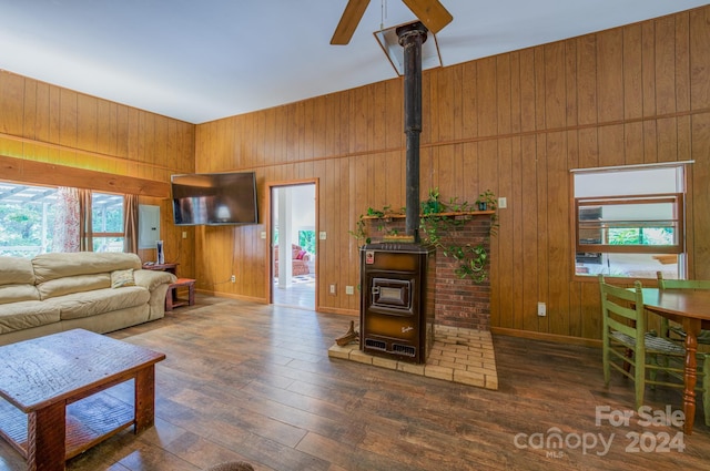 living room with a wood stove and wood walls