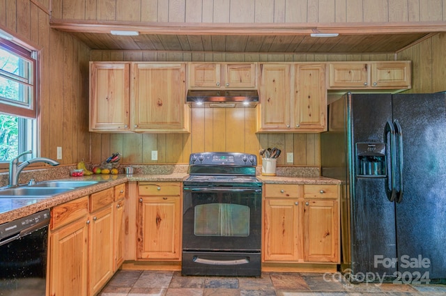 kitchen with wood walls, wooden ceiling, light brown cabinets, black appliances, and sink